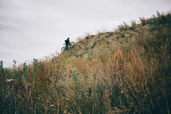 A cyclist riding to top of the hill — Stock Photo, Image