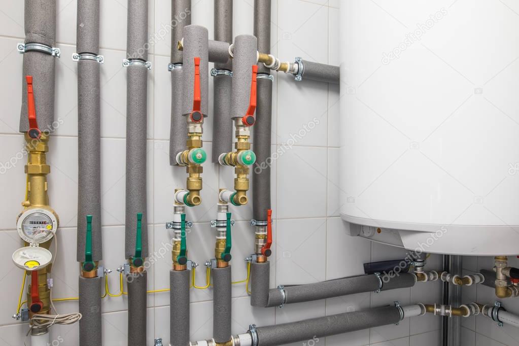 white boiler for water heating and  piping system with grey pipe