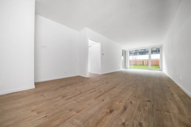 Beyaz duvarları ve penceresi olan boş bir oda, yeni bir bina.