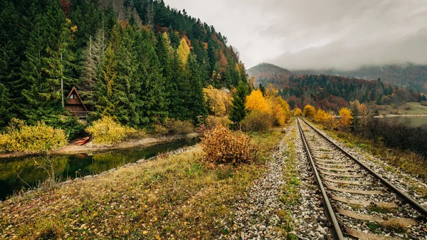 Sentiero ferroviario attraverso le montagne vicino al lago, colori autunnali — Foto Stock
