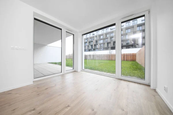 Beyaz duvarları ve penceresi olan boş bir oda, yeni bir bina.