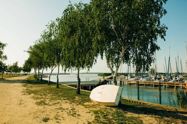 Un pequeño bote blanco apoyado contra un árbol en un camping austriaco — Foto de Stock