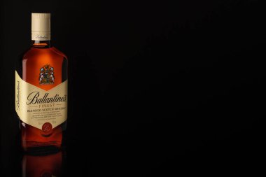 En iyi karıştırılmış viski şişesi. Siyah arka planda, camda yansıması olan viski.