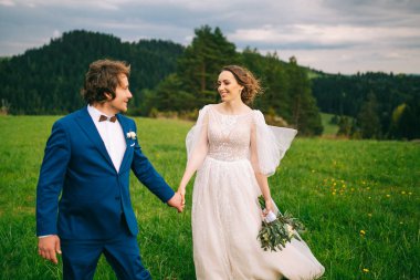 Yeşil doğada poz veren genç bir çift.