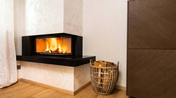 Modern, minimalist şömine odanın köşesinde.