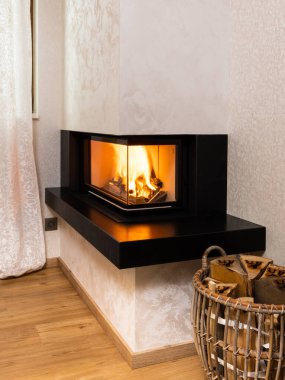 Modern, minimalist şömine odanın köşesinde.