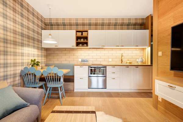 kitchen in wooden paneled apartment with blue accessories