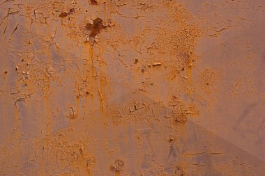 An old, rusty, colored plate with traces of background painting