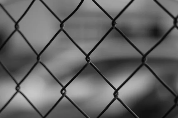 Metal fence with the car in the background — Stock Photo, Image