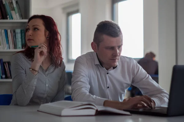 Gyönyörű vörös hajú lány és jóképű szőke srác dolgozik a proje — Stock Fotó