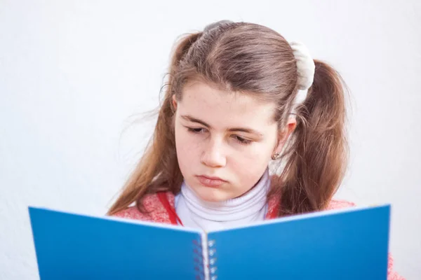 Hermosa linda niña rubia mirando en un libro en cuestión. O — Foto de Stock