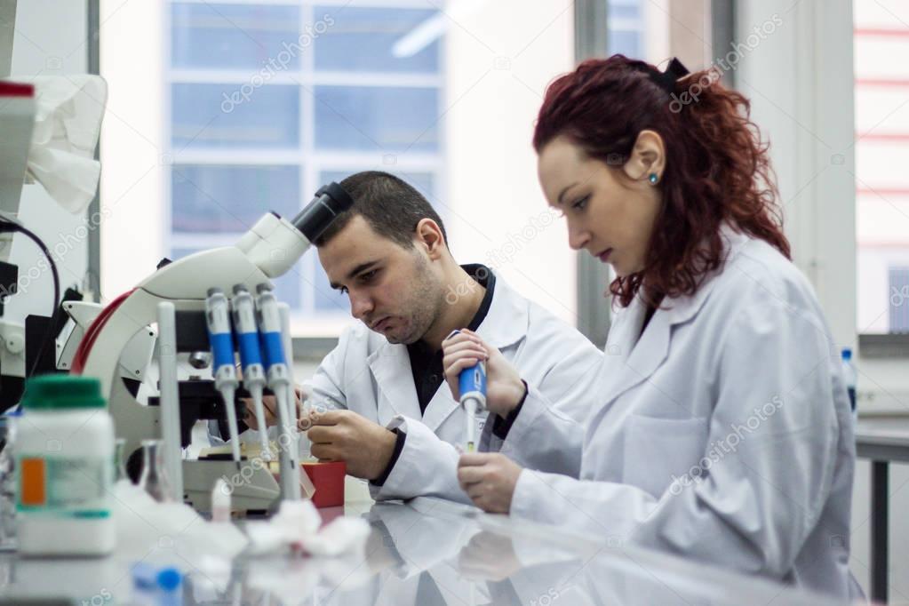 Modern scientist working with pipette in biotechnology laborator