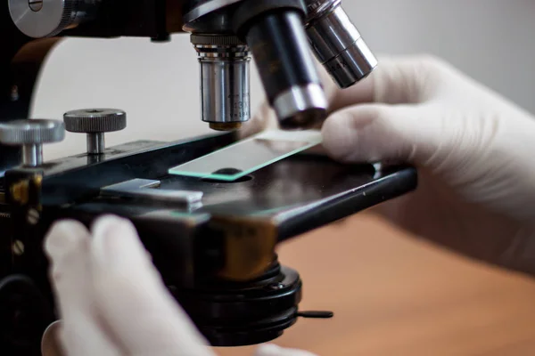 Egy fiatal orvos tanulmány a Mikroszkóp, gondosan gazdaság másolatát — Stock Fotó