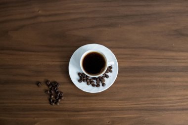 Ahşap arka plan, yeşil kahve aro ile bir fincan kahve kurtardı