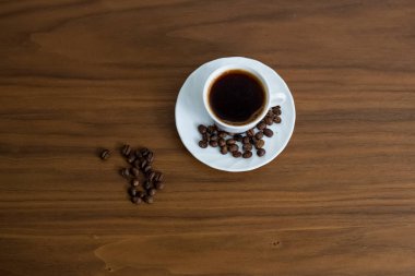 Ahşap arka plan, yeşil kahve aro ile bir fincan kahve kurtardı