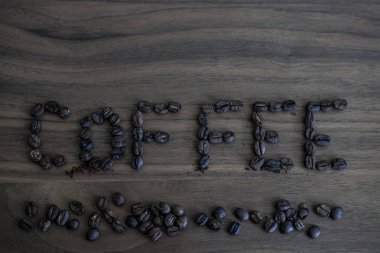 Yeşil kahve çekirdekleri, masaya dağılmış ve yazılı kahve, b