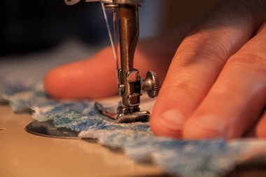 İşlem, bir bez tutan kadınların elleri Dikiş dikiş makinesi