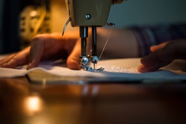 İşlem, bir bez tutan kadınların elleri Dikiş dikiş makinesi