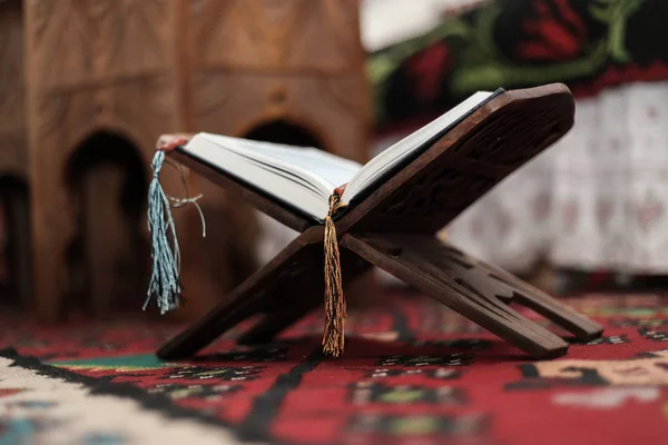 Libro Sagrado del Corán de los Musulmanes, un libro abierto en un stand con rosario — Foto de Stock