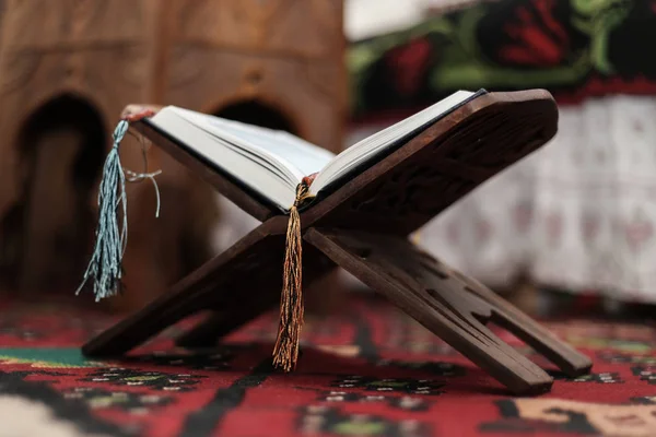 Libro Sagrado del Corán de los Musulmanes, un libro abierto en un stand con rosario — Foto de Stock