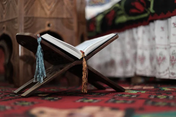 Libro Sagrado del Corán de los Musulmanes, un libro abierto en un stand con rosario — Foto de Stock