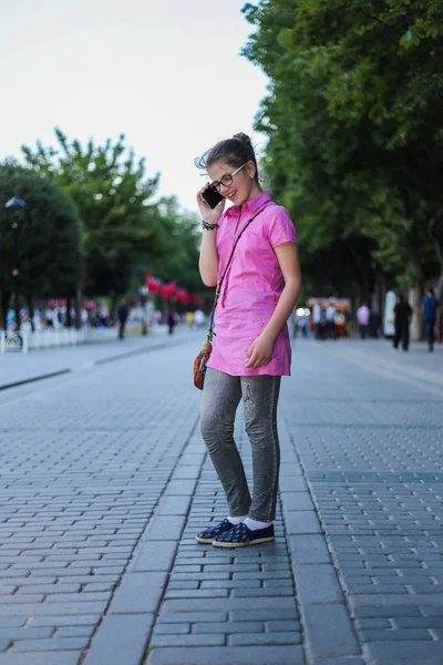 Giovane ragazza blu per strada, sorridere in faccia mentre parla su ce — Foto Stock