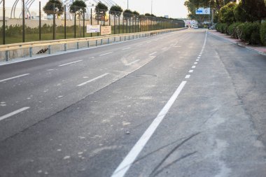 Beyaz şeritli yerel gri sokak yol. Ağaçlar ve MDBF s