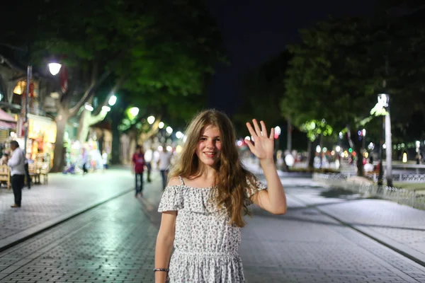 Giovane bionda carina e felice ragazza che saluta in strada con allegria — Foto Stock