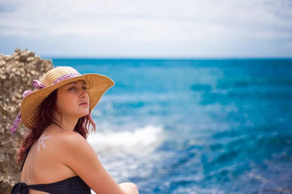 Une jeune fille sur une plage avec un chapeau, soleil et jouit du soleil, sur t — Photo