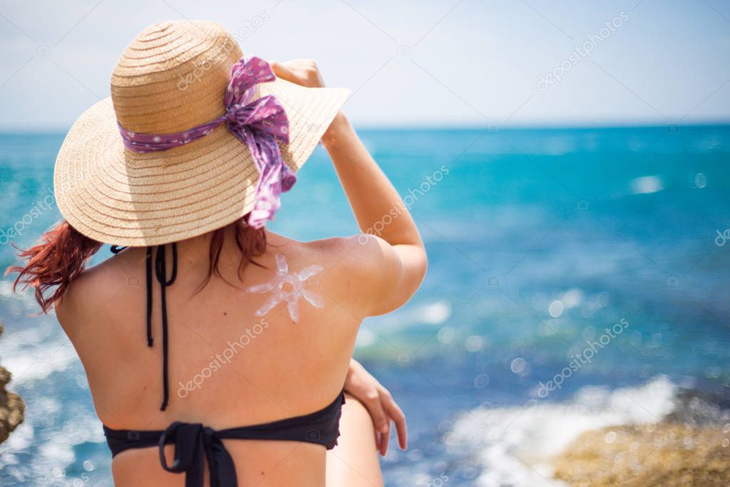 A young girl on a beach with a hat, sun and enjoys the sun, on t