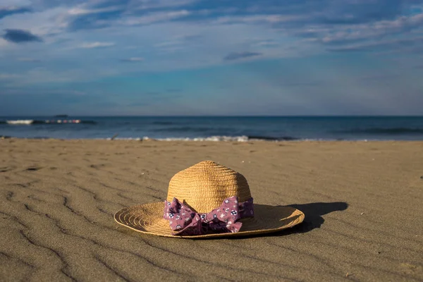 Hermoso sombrero con lazo púrpura colocación en una arena de ensueño bea — Foto de Stock