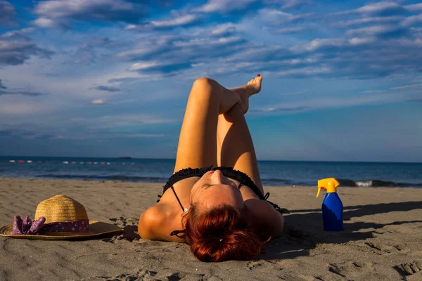 Jeune belle rousse bronzée posée sur une plage de sable avec un — Photo