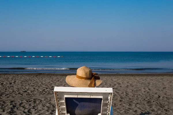 Una joven en la playa, disfrutando de un descanso al sol junto al mar en un — Foto de Stock