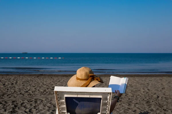 Una joven en la playa, disfrutando de un descanso al sol junto al mar en un — Foto de Stock