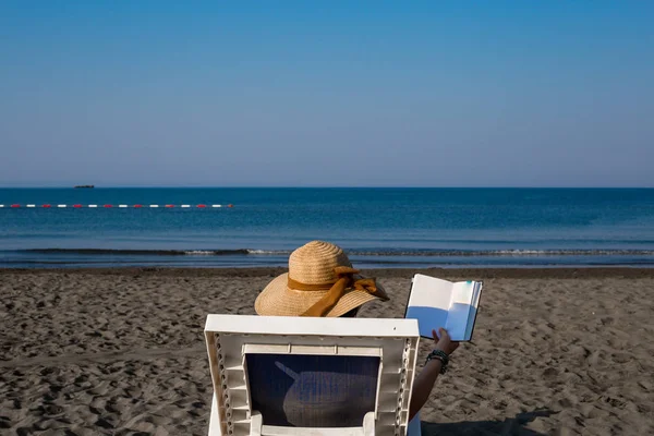 Una joven en la playa, disfrutando de un descanso al sol junto al mar en un — Foto de Stock
