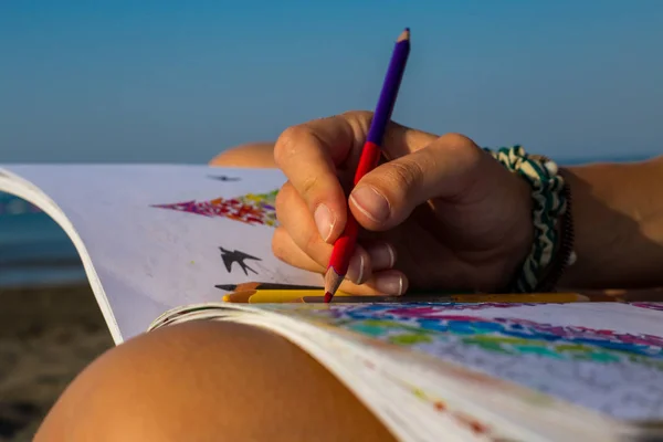 Giovane ragazza sulla spiaggia, godendo il sole, berretto sulla testa, sedersi — Foto Stock