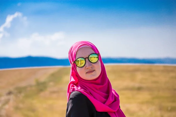 Omfattas muslimska kaukasiska tjej med rosa hijab och reflekterande bla — Stockfoto