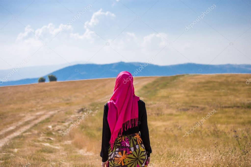 Covered muslim caucasian girl with pink hijab and colorful long 