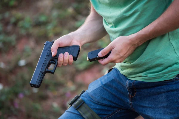 Guy dengan pistol glock gurun elang mengubah peluru dalam t — Stok Foto
