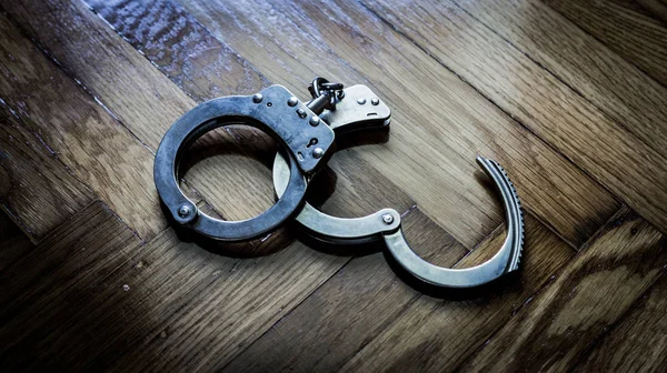 Полицейские наручники за поимку полураскрытых преступников и драку — стоковое фото