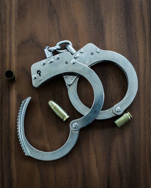 Handcuffs for catching criminals by police on a wooden backgroun — Stock Photo, Image