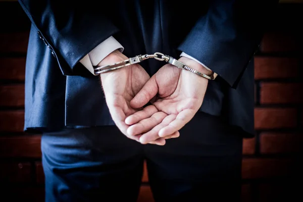Businessman with hands on the back and handcuffs on. Arrested fo — Stock Photo, Image