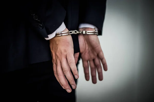 Бизнесмен арестован с наручниками на спине за коррупцию — стоковое фото