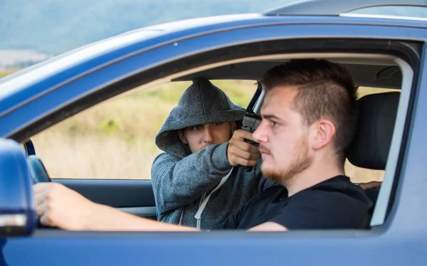 Вор, преступник с пистолетной угрозой, пытается украсть машину. , — стоковое фото