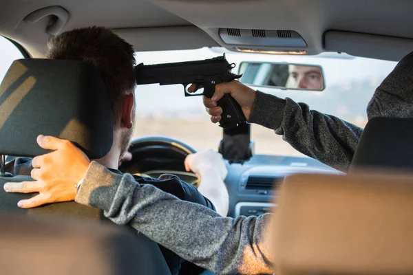 Bir hırsız, bir suçlu bir tabanca tehdidiyle bir araba çalmak için çalışır, — Stok fotoğraf