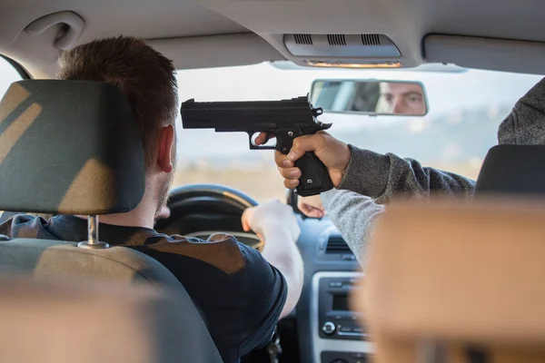 Un ladrón, un criminal con una amenaza de pistola, trata de robar un coche , — Foto de Stock