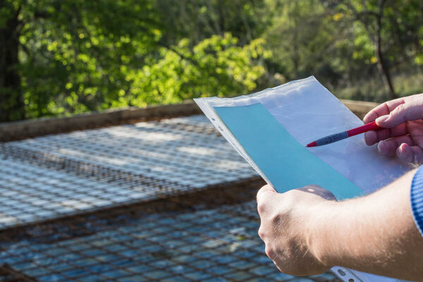 The architect keeps the papers with the project and looks at the