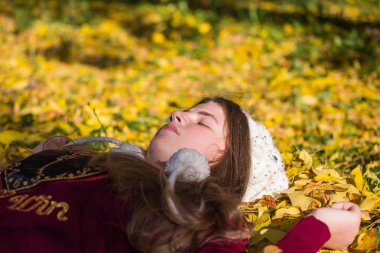 Genç sarışın kız sonbahar, altın sarı fo güneşli bir günde sahiptir