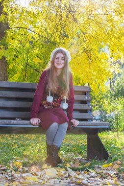 Genç sarışın kız sonbahar, altın sarı fo güneşli bir günde sahiptir