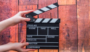 Clapper plakaları, kadınların el ve film clapper ahşap bir backg üzerinde